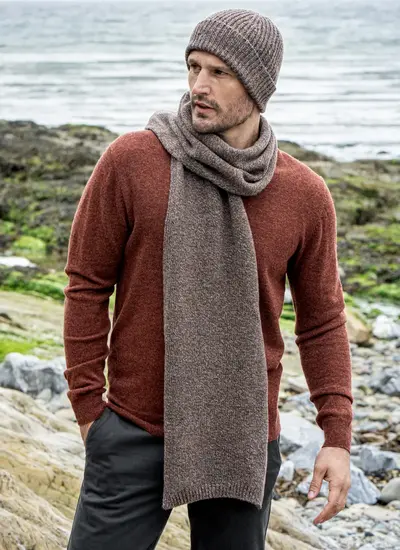 Personalized cashmere wool scarf in hazel brown, made in Ireland, styled with rust sweater and coastal backdrop